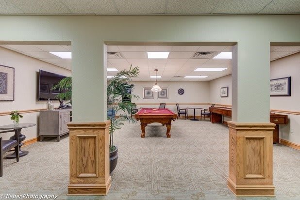 A spacious recreation room featuring a pool table and comfortable seating.