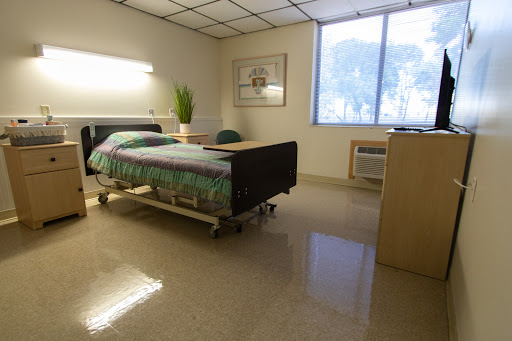 A clean and well-lit hospital room featuring a bed and minimal furniture.