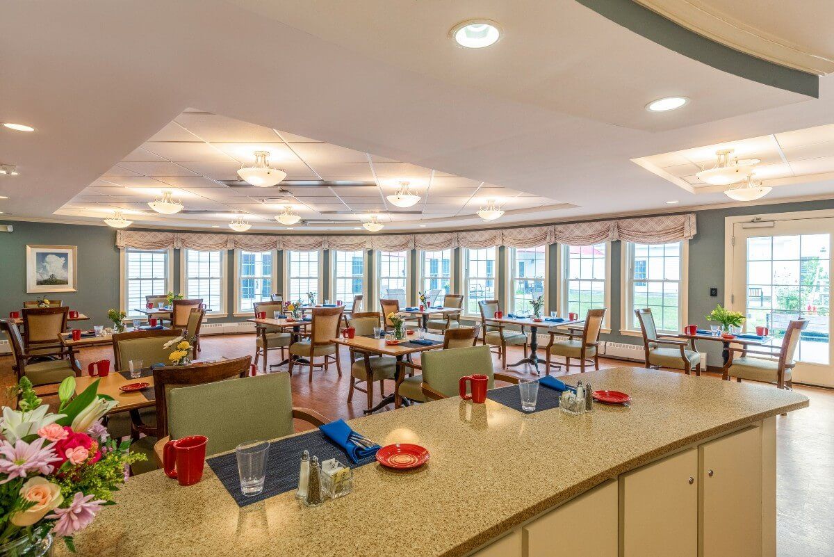A spacious dining area with neatly arranged tables and large windows providing ample natural light.
