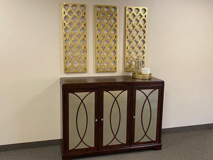 A stylish wooden cabinet adorned with decorative wall panels above it.