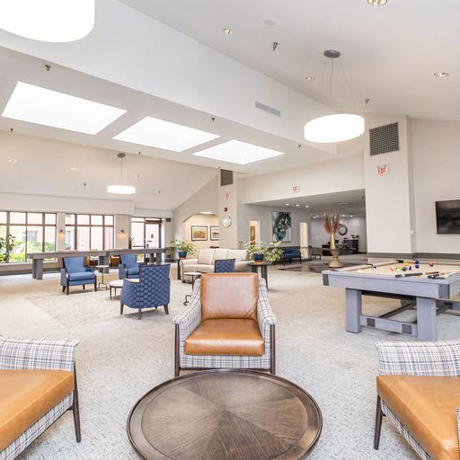 A spacious and modern game room featuring a pool table and comfortable seating.