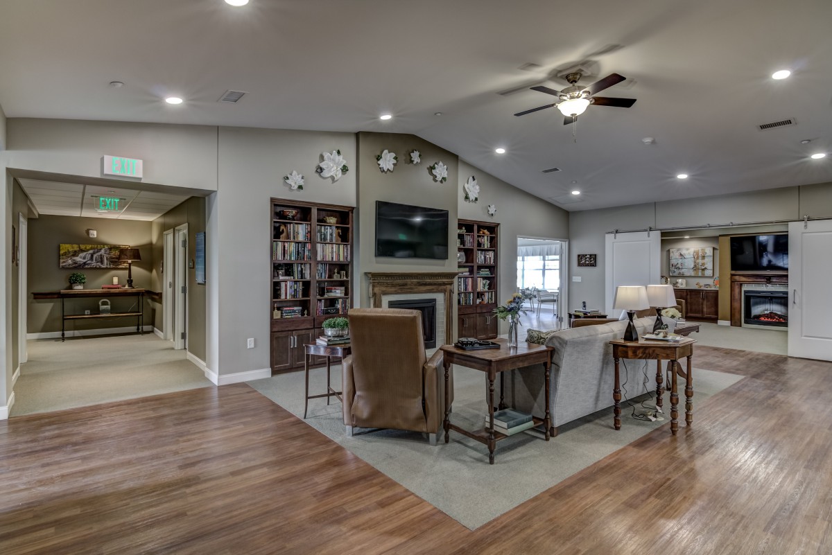 A cozy and modern living room with a fireplace and built-in bookshelves.