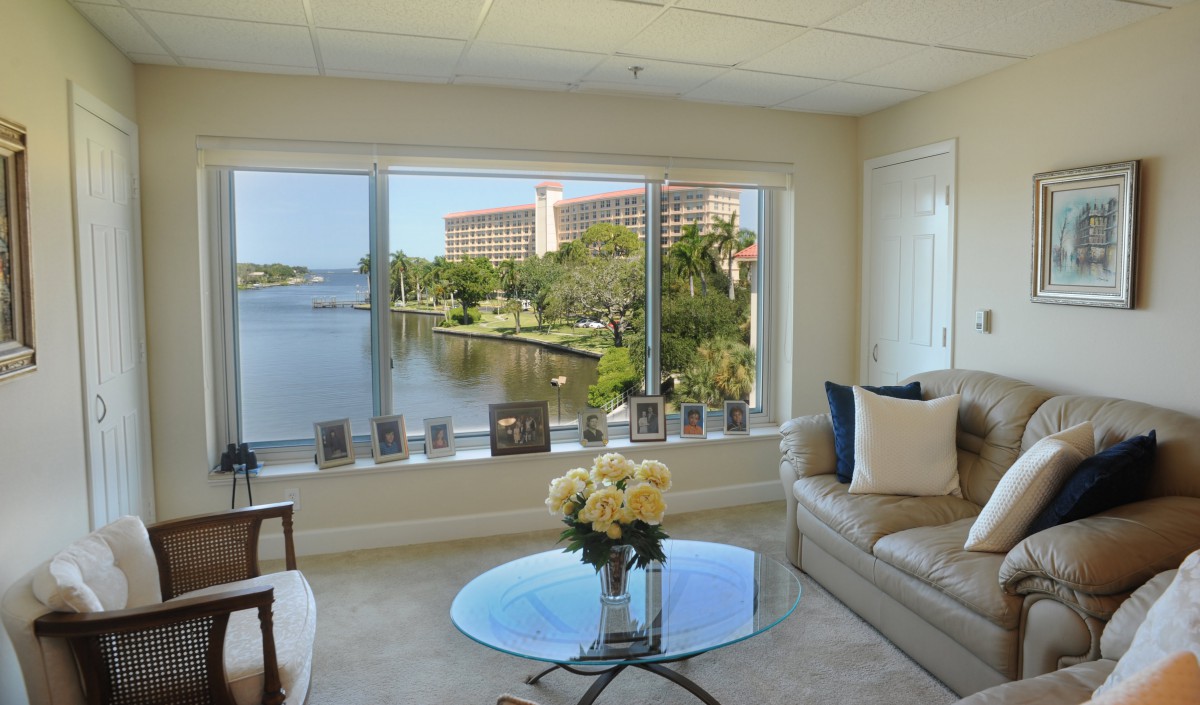 A modern living room featuring large windows with a scenic lake view.