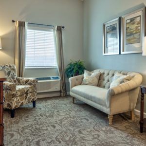A cozy living room with a sofa, armchair, and decorative elements.
