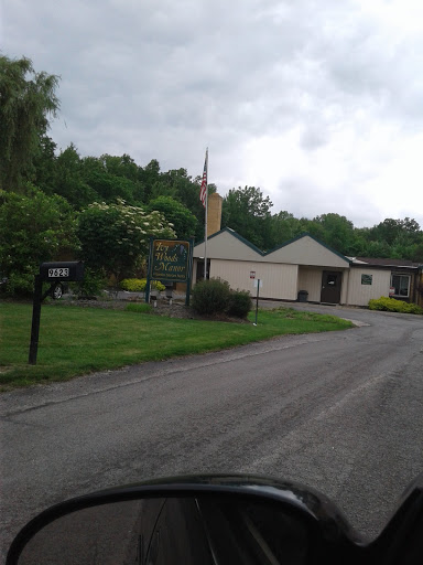 A quiet residential area with lush greenery and a cloudy sky.