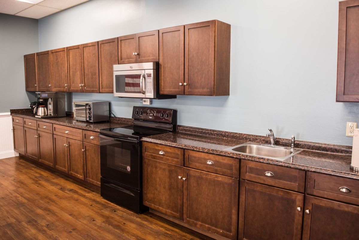A modern kitchen with wooden cabinets and various appliances.