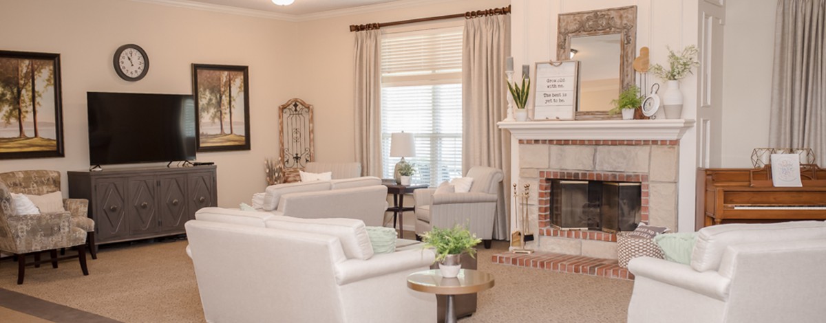 A cozy living room with neutral decor and a fireplace.