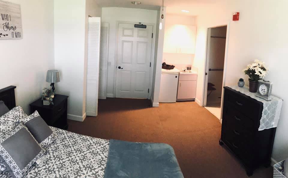 A cozy hotel room with a view of the entrance and a small laundry area.