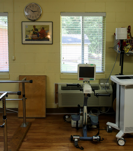 A therapeutic room equipped with various medical devices and sunlight filtering through the window.