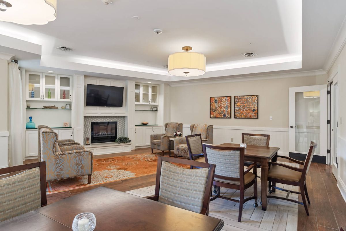 A modern living room with comfortable seating, a television above a fireplace, and tasteful decor.