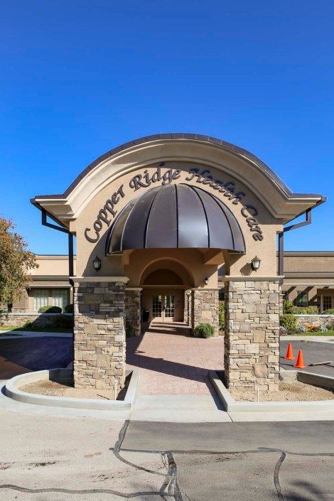 Entrance of a building with stone columns and an arched awning.