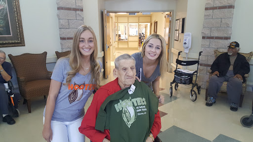 A joyful moment shared between two young women and an elderly man, showcasing a sense of community and connection.