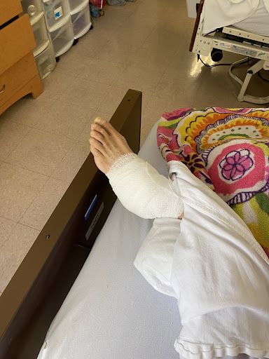A bandaged foot resting on a hospital bed, indicating medical treatment and recovery.