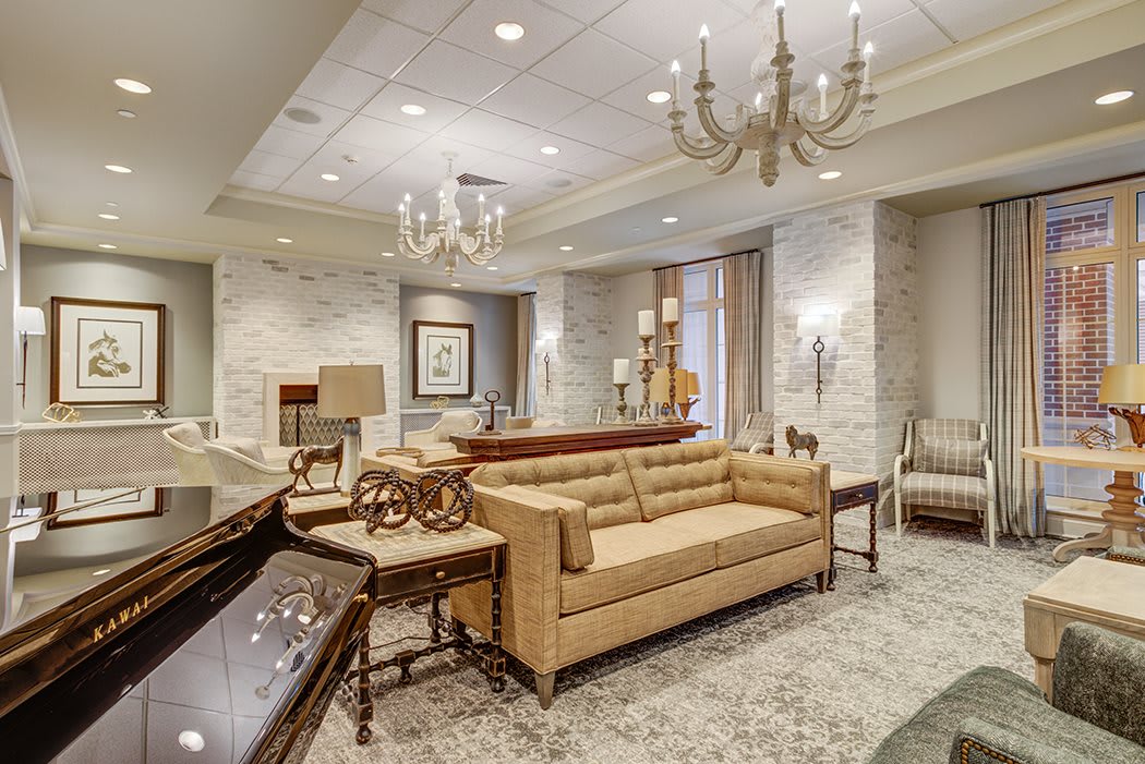 A luxurious and elegantly designed living room with plush furniture and chandeliers.