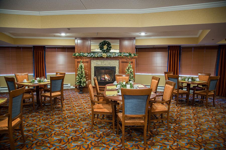 A cozy dining room with a fireplace and decorated with festive accents.