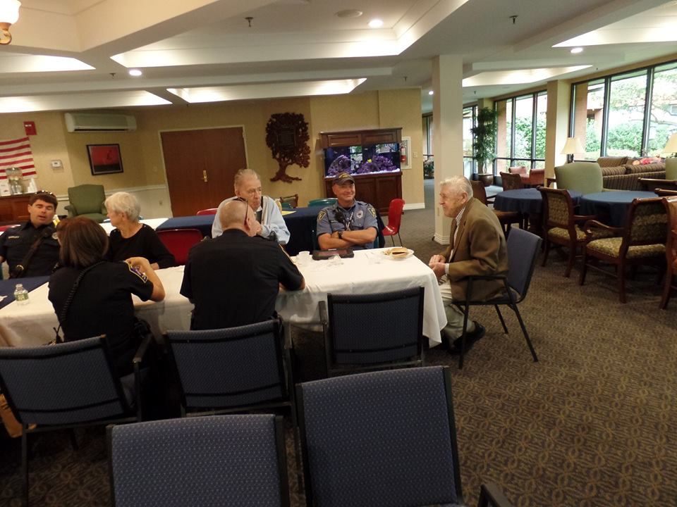 A group of people sitting around a table having a conversation in a dining area.