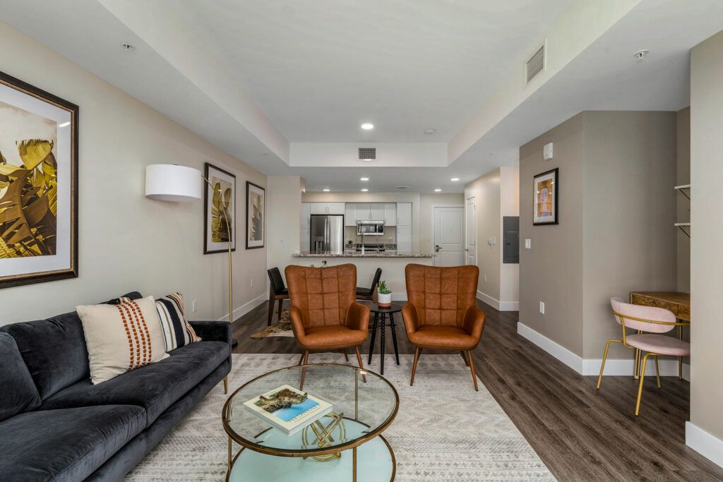 A modern open-plan living room with stylish furniture and a connected kitchen.