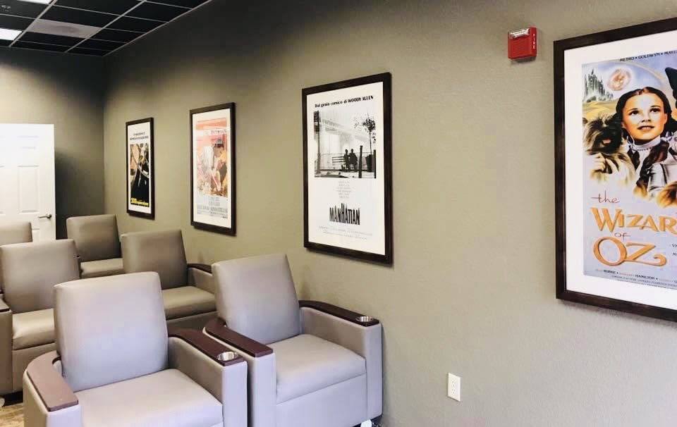 A waiting room with chairs and framed posters on the wall.