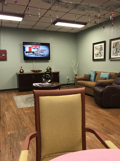 A cozy waiting room featuring comfortable seating, a TV, and decorative artwork.