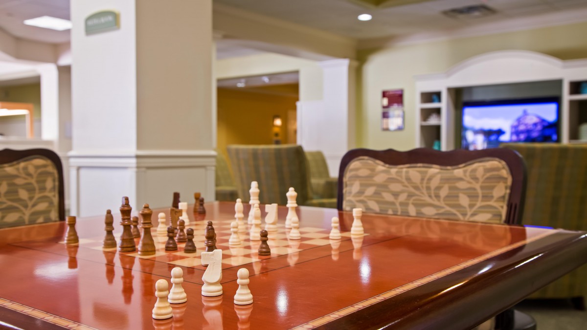 A chessboard set up in a cozy indoor recreation area.