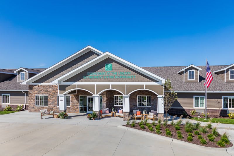 A modern residential building with well-maintained landscaping and outdoor seating.