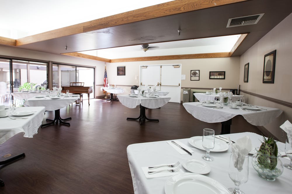 An empty restaurant dining room with neatly set tables.
