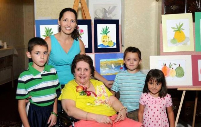 A family group gathers for a photo in front of colorful artwork.