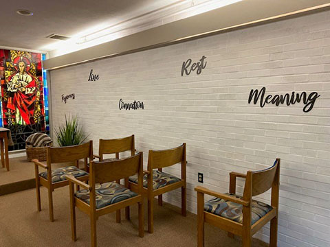 A tranquil waiting area featuring wooden chairs and inspirational words on the wall.