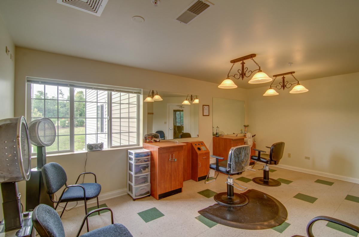 An interior view of a hair salon with chairs, mirrors, and lighting fixtures.