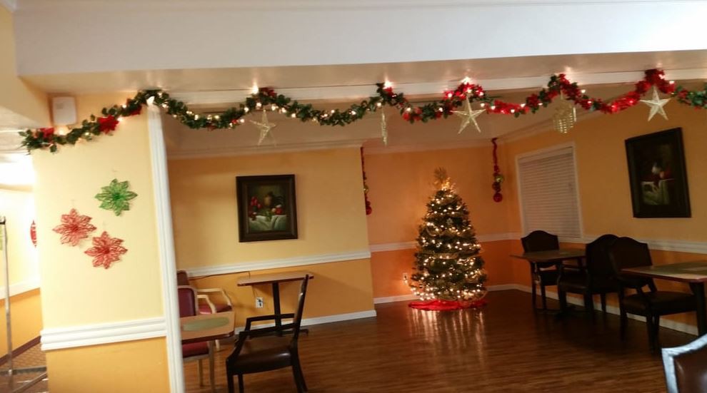 A warmly decorated room with a Christmas tree and festive garlands hanging from the ceiling.
