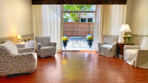 A cozy living room with a view of the outdoors, featuring comfortable seating and natural light.