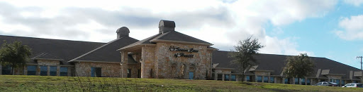 A stone-faced building with a prominent sign, set against a cloudy sky.