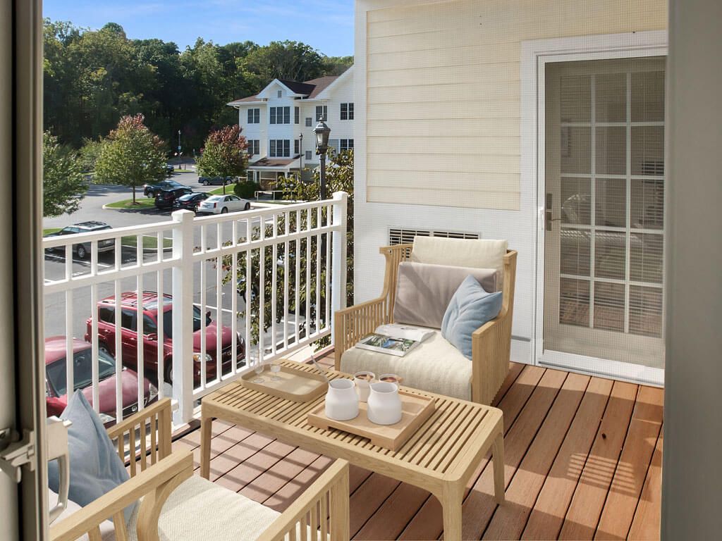 A cozy apartment balcony featuring wooden furniture with a scenic view of the surroundings.
