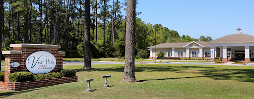 A peaceful outdoor setting featuring tall trees and a well-maintained building.