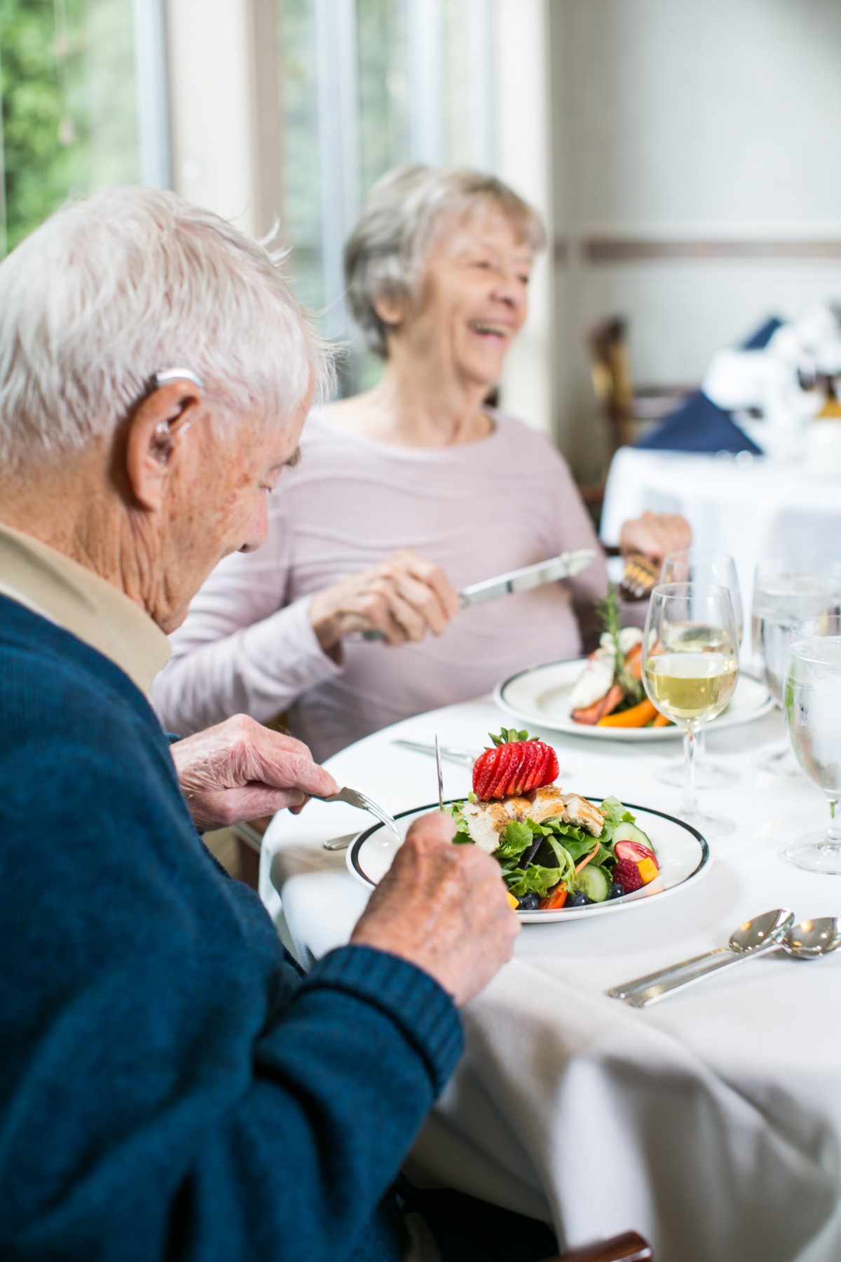 An elderly couple enjoying a meal together at a restaurant.