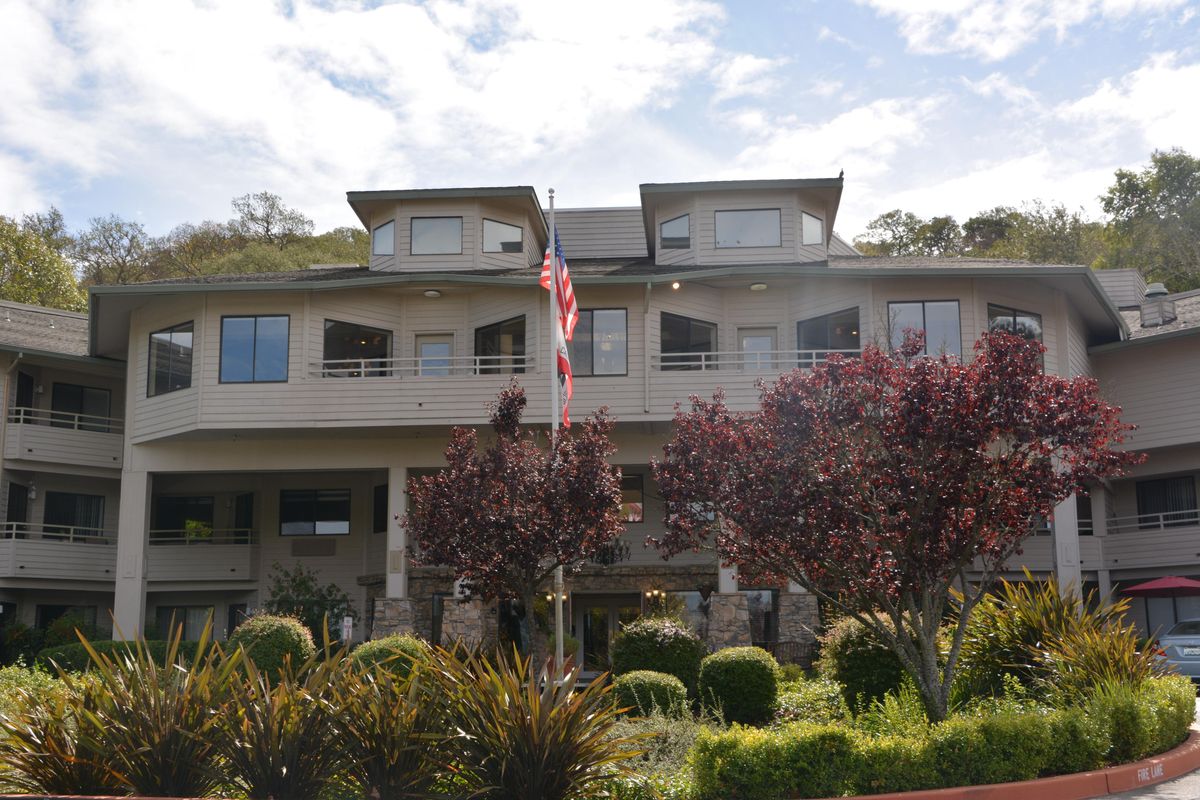 A large house with a front garden and an American flag flying in the yard.