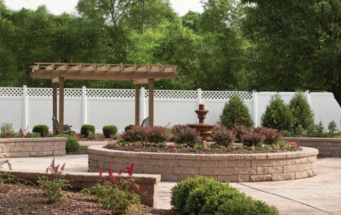 A beautifully landscaped garden featuring a pergola, fountain, and neatly arranged shrubs.