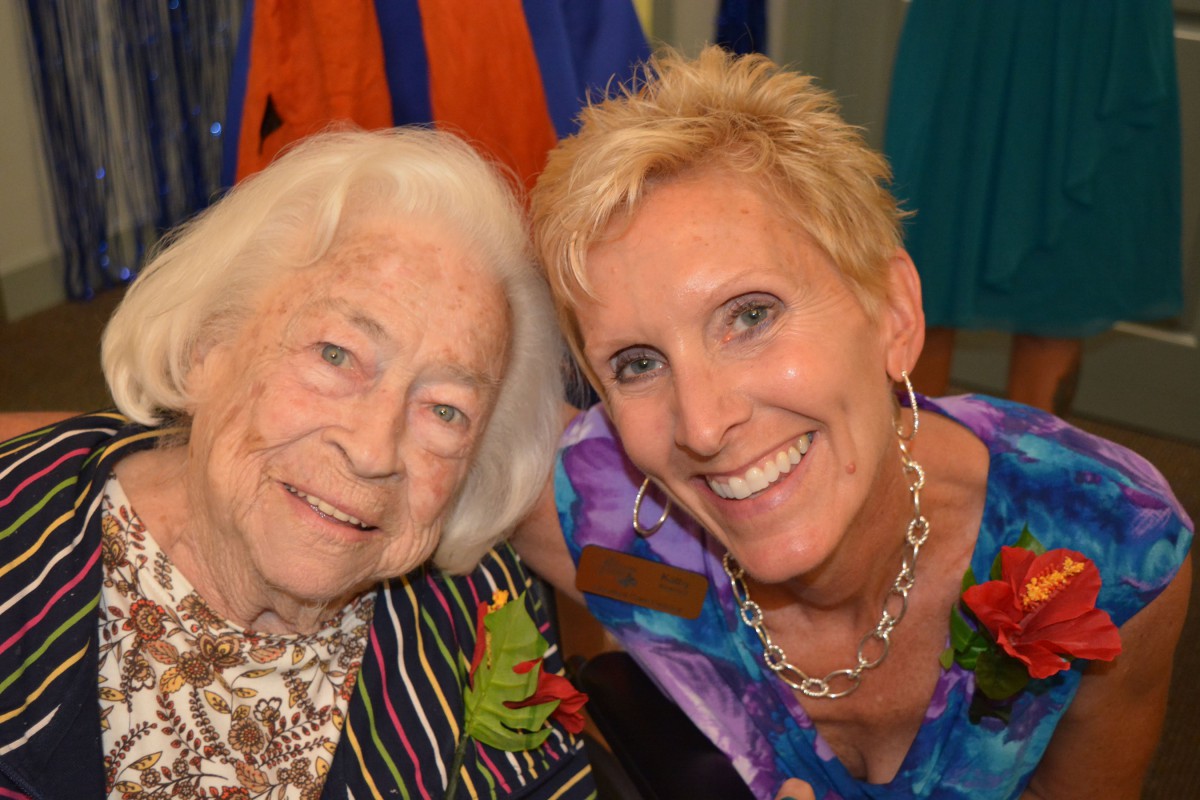 Two smiling women pose together, showing a sense of closeness and joy.