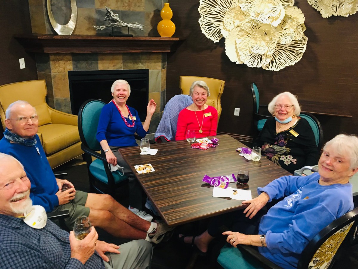 A group of elderly people enjoying a social gathering around a table indoors.