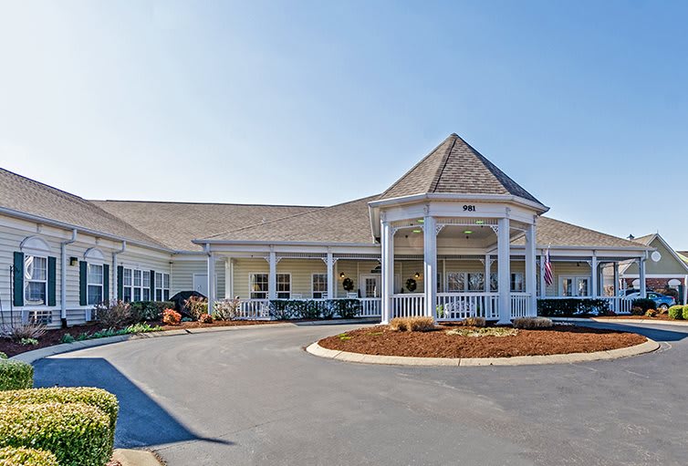 A large residential building with a prominent entrance and circular driveway.