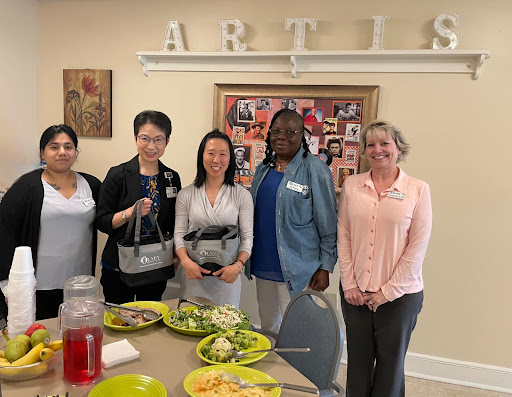 A diverse group of individuals gathered for a community lunch, enjoying food and each other's company.