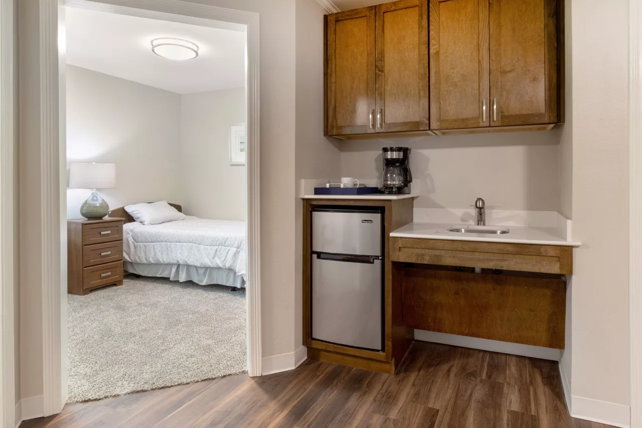 A modern apartment with a kitchenette and an adjoining bedroom.