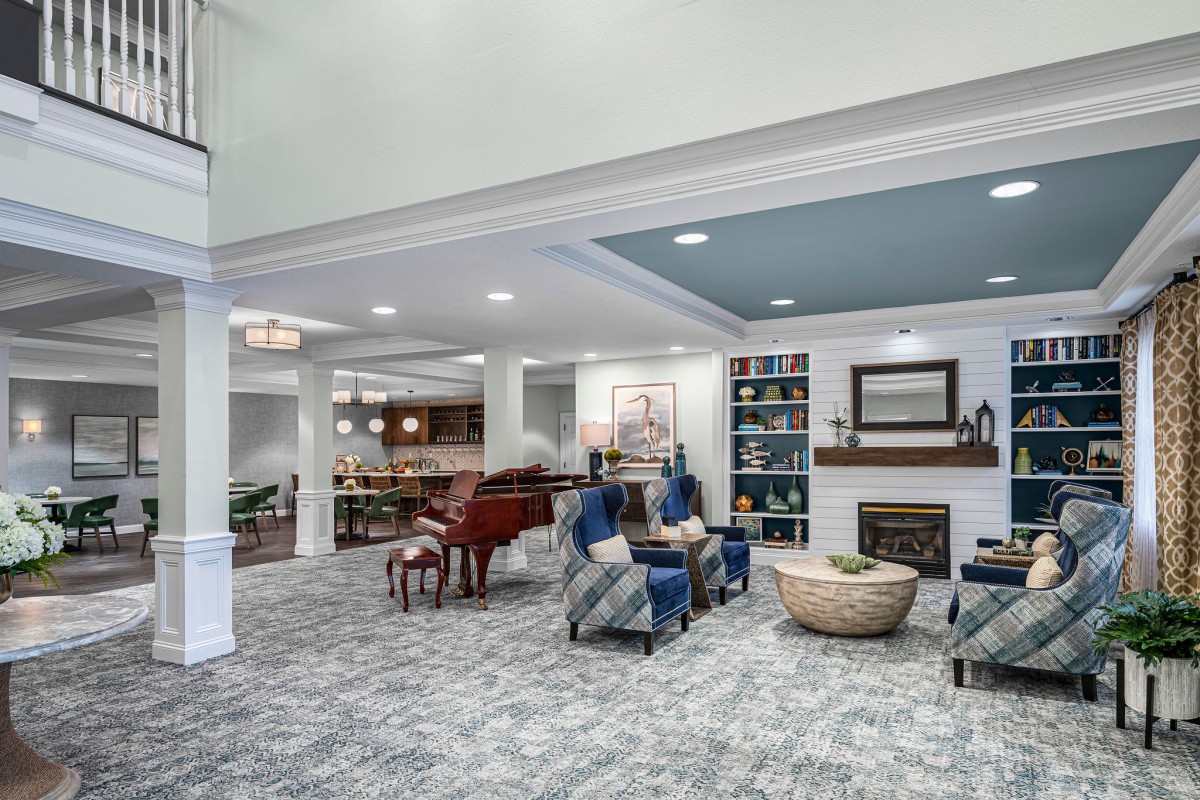 A spacious living room featuring a grand piano, comfortable seating area, and a cozy fireplace.