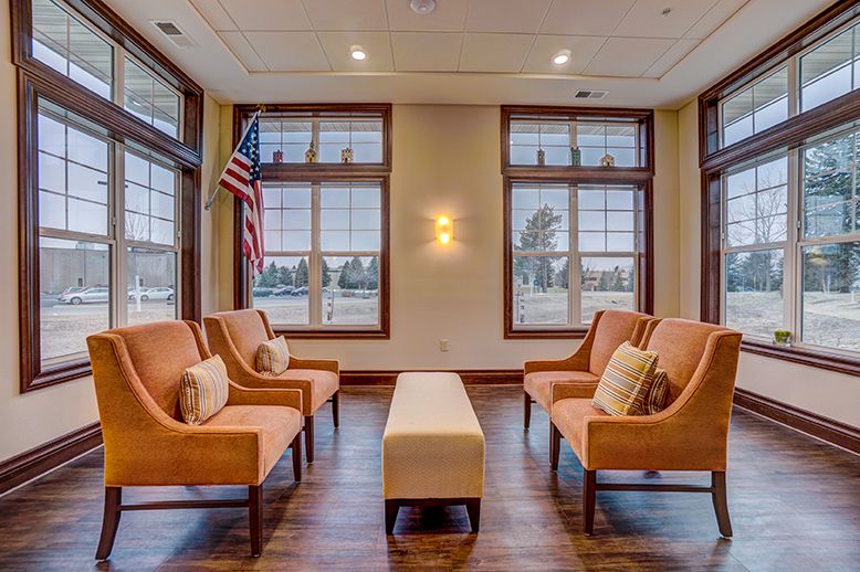 A cozy waiting area with cushioned chairs and large windows.