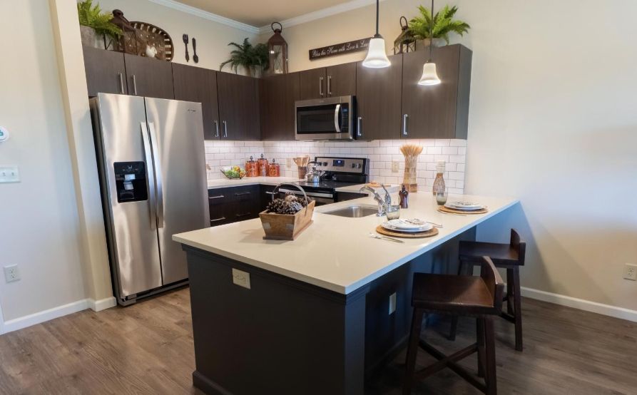 A modern kitchen featuring stainless steel appliances and a central island with pendant lighting.