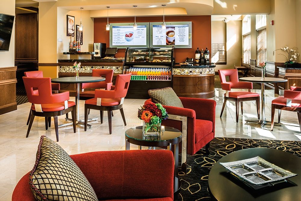 A cozy cafe interior with comfortable seating and a menu display at the counter.