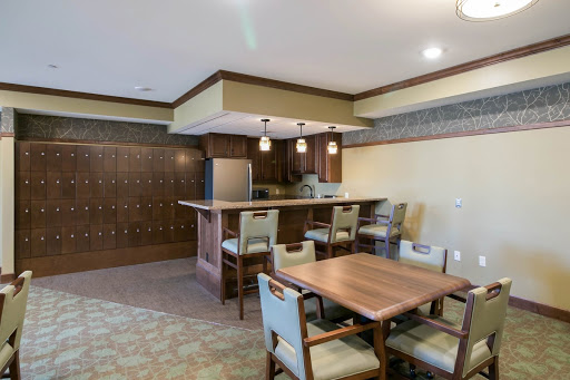 A modern kitchen and dining area featuring a wooden table, bar counter, and contemporary decor.