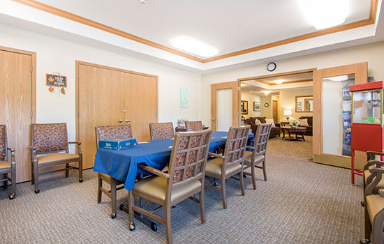 A well-lit dining or meeting area featuring a long table and chairs arranged neatly.