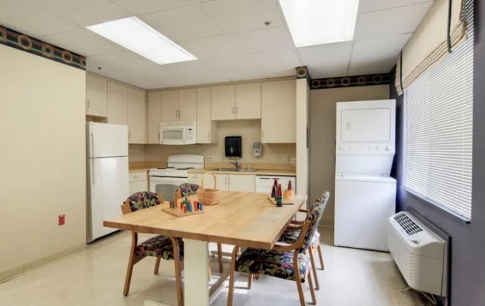 A cozy kitchen and dining area with modern appliances and a wooden table.