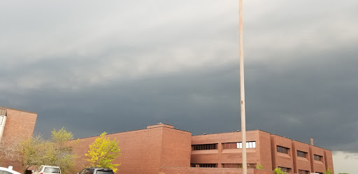 A dark and gloomy sky looms over a brick building, hinting at an approaching storm.